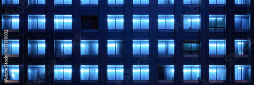 Seamless skyscraper facade with blue tinted windows and blinds at night