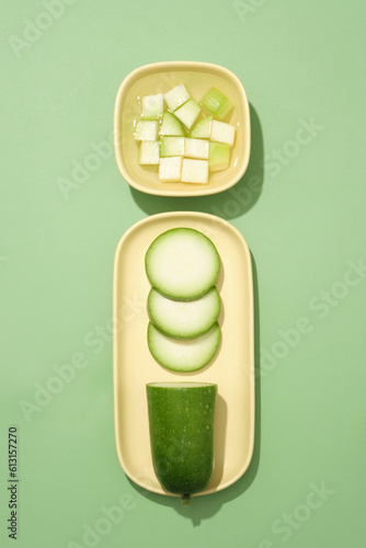 Pastel dish in oval-shaped and a bowl filled with liquid and winter melon slices. Winter melon (Benincasa hispida) could be highly helpful in healthy weight loss photo