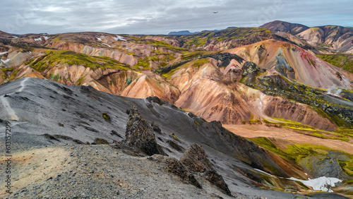 Beautiful panoramic Icelandic landscape of colorful rainbow volcanic Landmannalaugar mountains, at famous Laugavegur hiking trail with dramatic snowy sky, and red volcano soil in Iceland.