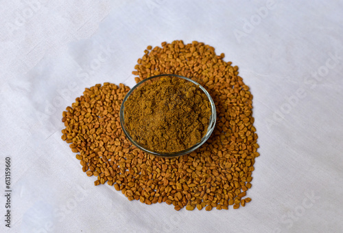 Fenugreek Seeds (Methi Dana) in heart shape on white background. Shambhala or helba seeds is a traditional Indian seasoning Ayurvedic food. Used in culinary and medicine. photo