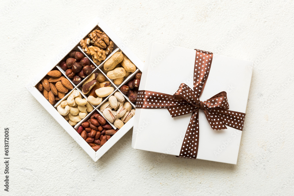 Various varieties of nuts lying in paper box on table background. Top view. Healthy food. Close up, copy space, top view, flat lay. Walnut, pistachios, almonds, hazelnuts and cashews Various varieties of nuts lying in paper box on table background. Top view. Healthy food. Close up, copy space, top view, flat lay. Walnut, pistachios, almonds, hazelnuts and cashews