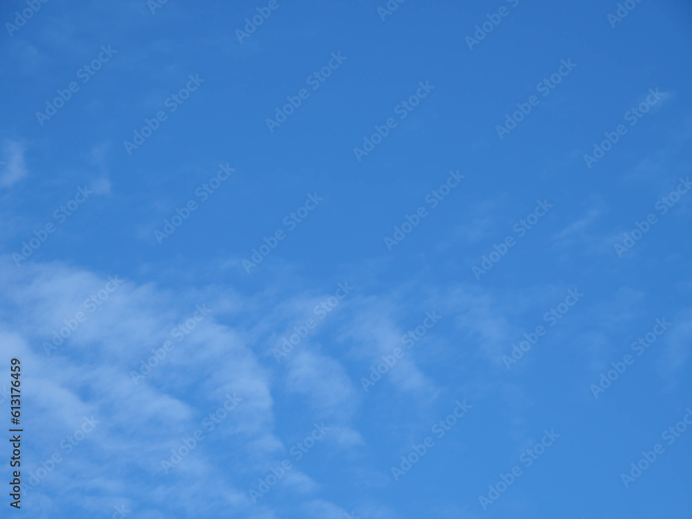 Fototapeta premium Blue sky background with white clouds shaped like fish tails.