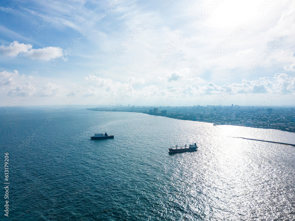 Aerial view of two large cargo tanker ships moored near a coastal city. Santo Domingo
