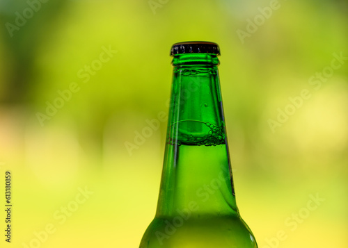 Zielona zamknięta butelka z kapslem na rozmytym tle