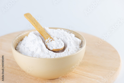 Tapioca starch in a bowl on a wooden board, light background. photo