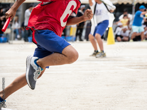 小学校の運動会でリレーを走る子供