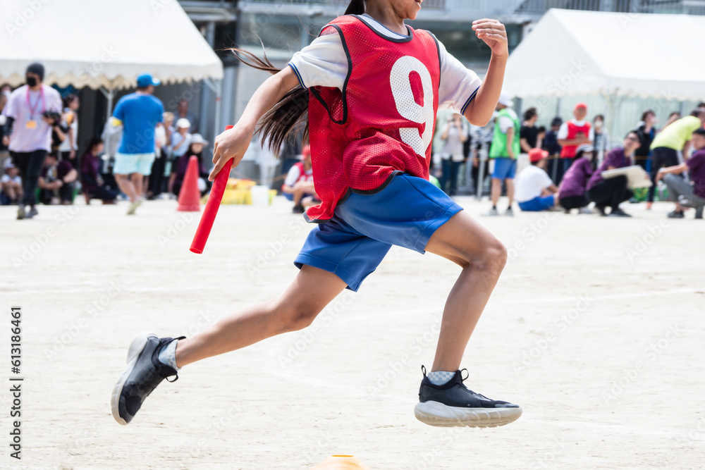 小学校の運動会でリレーを走る子供