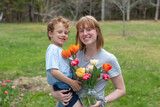 A portrait of a happy mom and son together in the backyard by the tulip garden. 