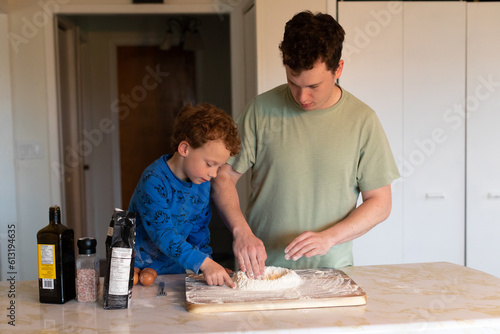 A father and son making some fresh pasta for dinner. 