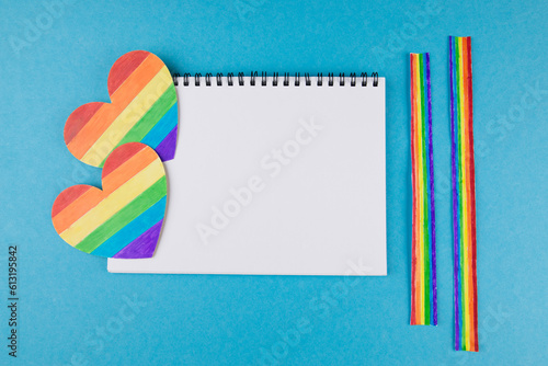 LGBT symbol, rainbow hearts with a blank notepad on a blue background, rights and gender equality.
