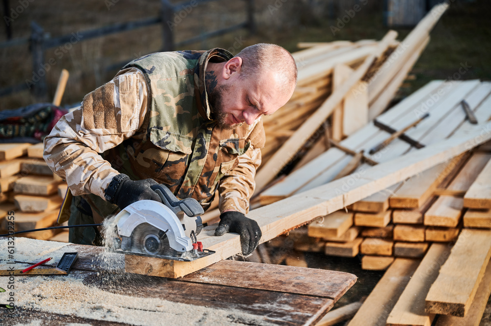 Carpenter using circular saw for cutting wood beam. Man worker building wooden frame house. Carpentry concept. Carpenter using circular saw for cutting wood beam. Man worker building wooden frame house. Carpentry concept.