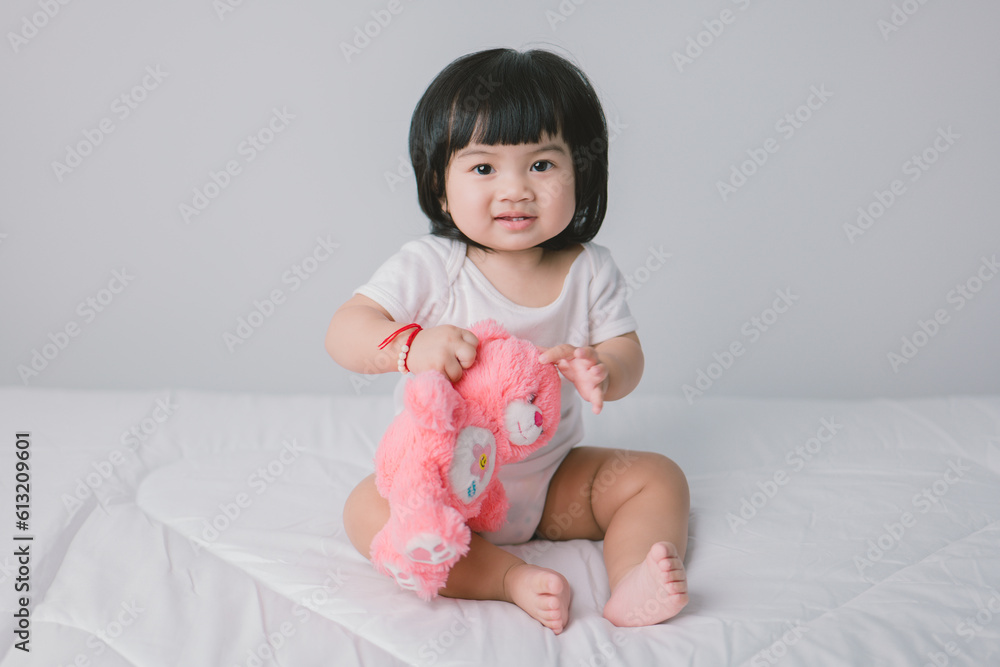 Happy Little Baby Girl Sitting On Bed with pink bear In Bedroom At Home. Happy Little Baby Girl Sitting On Bed with pink bear In Bedroom At Home.