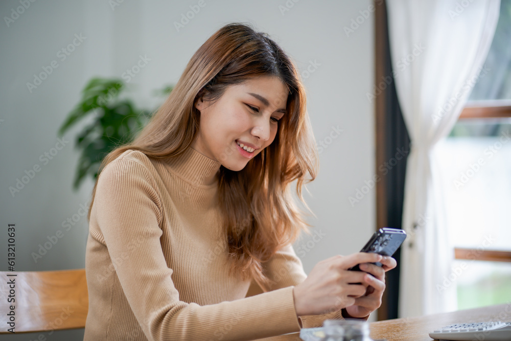 Asian woman texting checking social media holding smartphone at home Conversation with boyfriend or friend. Asian woman texting checking social media holding smartphone at home Conversation with boyfriend or friend.