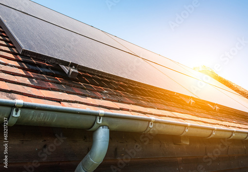 Dusty solar panels on roof of pool house against blue sky.  photo