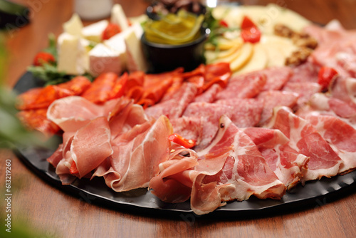 Appetizers buffet with tasty meat snacks, pickles, close-up. Cheese and cold cuts board, tapas. 