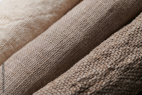 Linen in different textures and colors. Natural fabrics from organic flax and cotton in rolls, homespun textile handmade. Burlap and canvas for eco, rustic, boho, hygge decor .