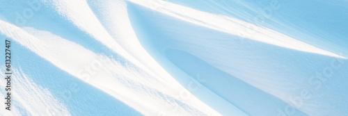 Snow texture. Wind sculpted patterns on snow surface. Wind in the tundra and in the mountains on the surface of the snow sculpts patterns and ridges (sastrugi). Arctic, Polar region. Winter background