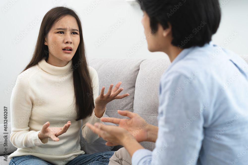 Family problems, Asian women cover her face and sit separately from husband feel disappointed after quarrels at home. Family problems, Asian women cover her face and sit separately from husband feel disappointed after quarrels at home.