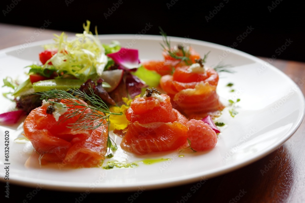 Salmon roses sushi rolls sashimi with caviar and mayonnaise on round white plate Salmon roses sushi rolls sashimi with caviar and mayonnaise on round white plate