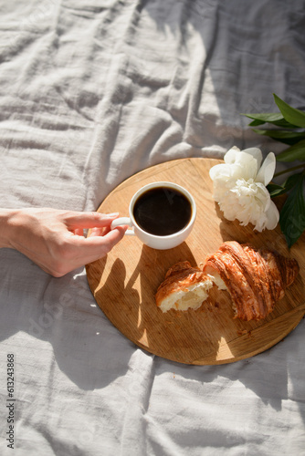 women hand taking cup of coffee in the morning in bed