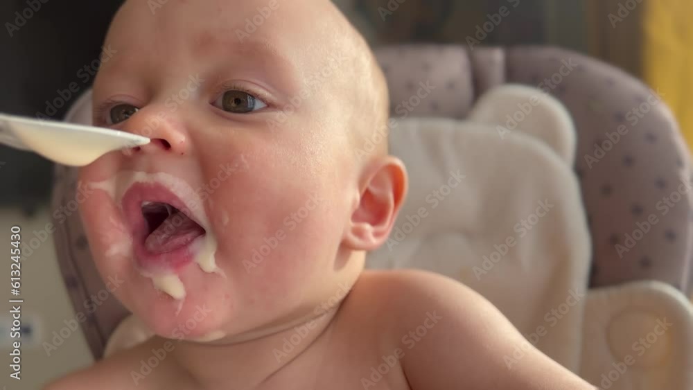 baby eats dirty. happy family kid a dream concept. baby funny got dirty in yogurt dairy product lifestyle all over his face in drops learns to eat. baby eats dirty at home at the feeding table baby eats dirty. happy family kid a dream concept. baby funny got dirty in yogurt dairy product lifestyle all over his face in drops learns to eat. baby eats dirty at home at the feeding table