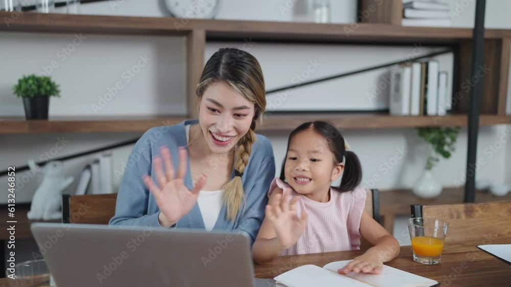 Cheerful asian mother and little daughter using laptop for video call having fun greetings online with father. Social distancing, Quarantine, Online communication Cheerful asian mother and little daughter using laptop for video call having fun greetings online with father. Social distancing, Quarantine, Online communication