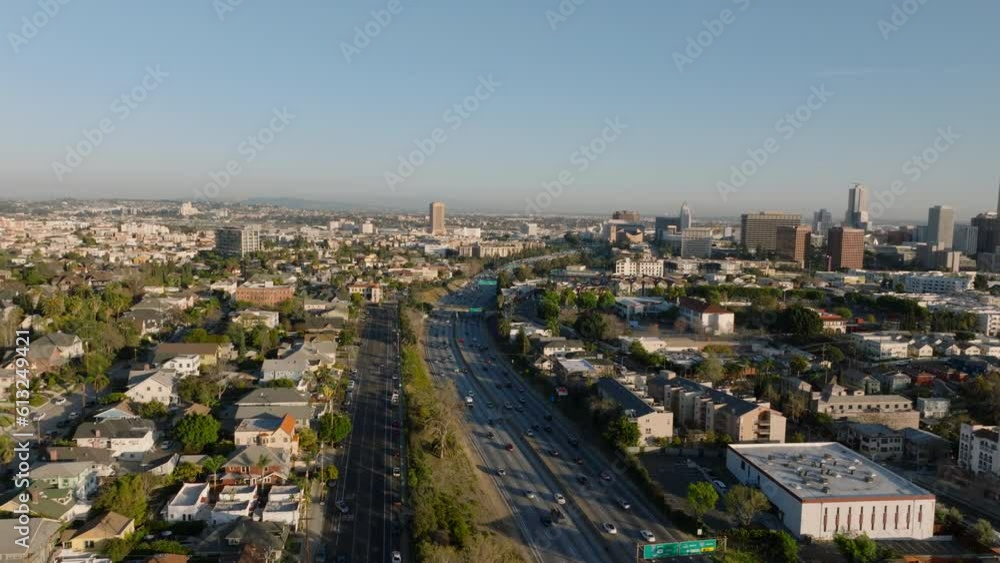 Forwards fly above large city at golden hour. Buildings in residential urban borough and busy multilane freeway leading by. Los Angeles, California, USA Forwards fly above large city at golden hour. Buildings in residential urban borough and busy multilane freeway leading by. Los Angeles, California, USA