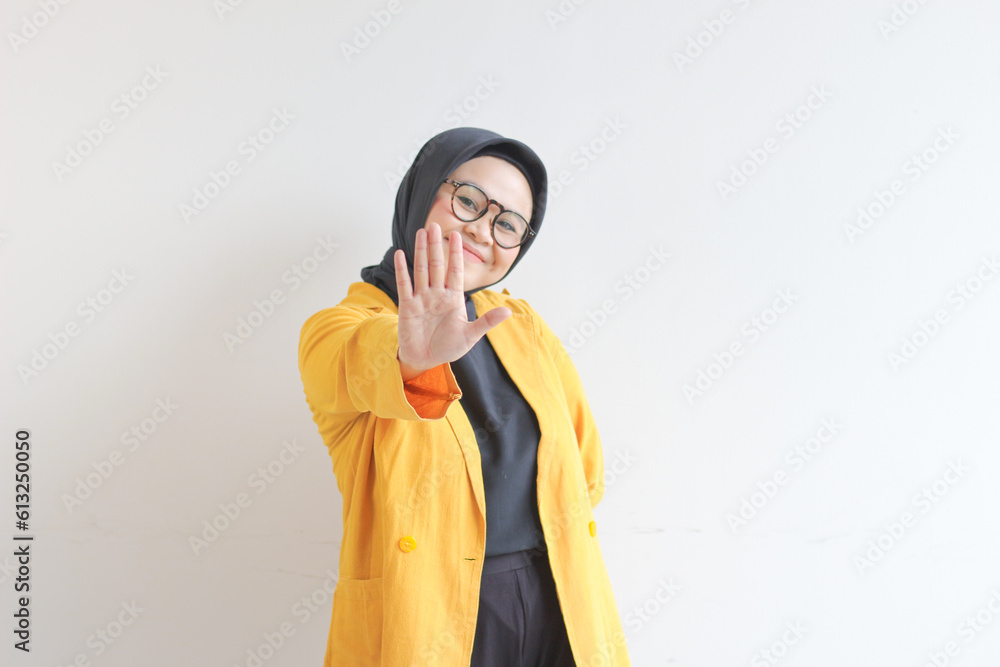 Beautiful young Asian Muslim woman, wearing glasses and yellow blazer showing palms while smiling isolated white background. advertising concept. Beautiful young Asian Muslim woman, wearing glasses and yellow blazer showing palms while smiling isolated white background. advertising concept.