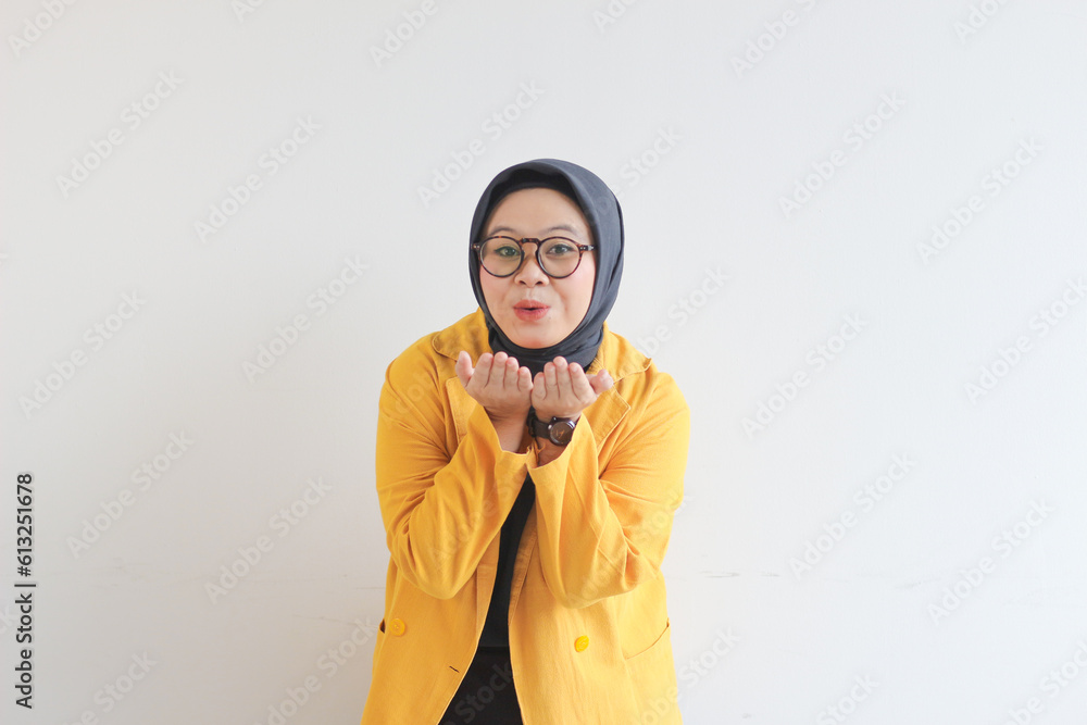 Young beautiful Asian Muslim woman, wearing glasses and yellow blazer with happy smiling face expression