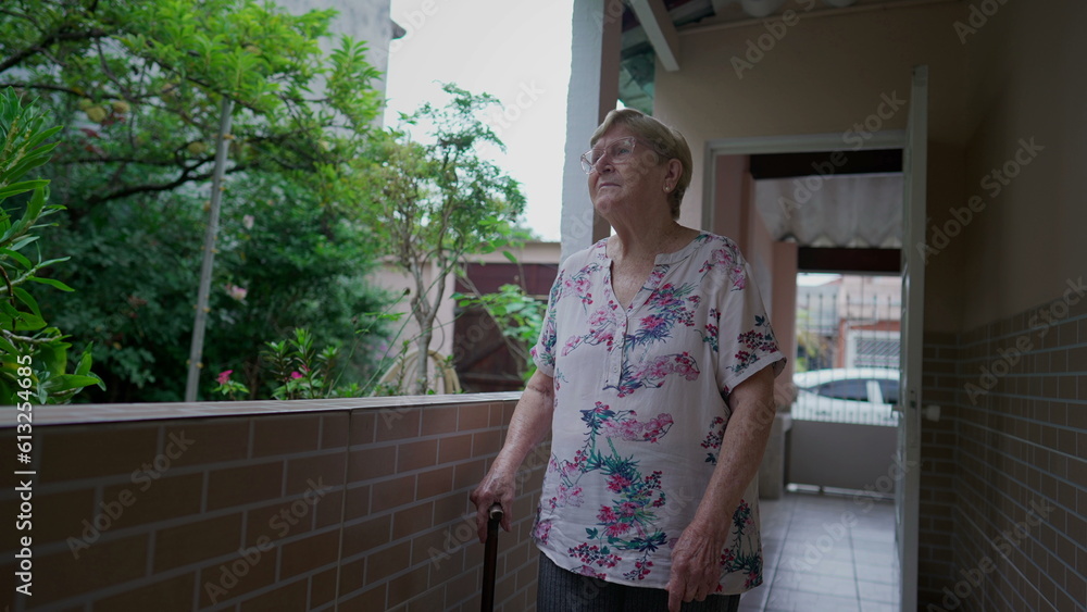 Pensive Elderly Woman Walking at home contemplating garden. Thoughtful older person in 80s walks with stick Pensive Elderly Woman Walking at home contemplating garden. Thoughtful older person in 80s walks with stick