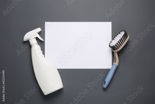 White blank sheet of paper and house cleaning equipment on darkl background. Template for design. Top view photo