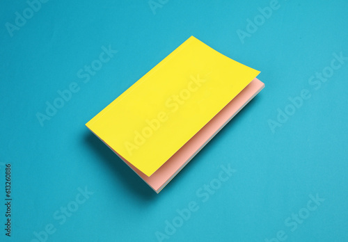 Notepad with a yellow cover floating on blue background