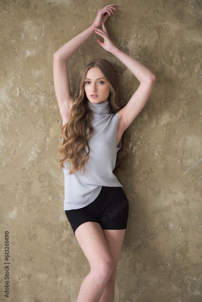 Young fashion woman posing near grey wall Young fashion woman posing near grey wall