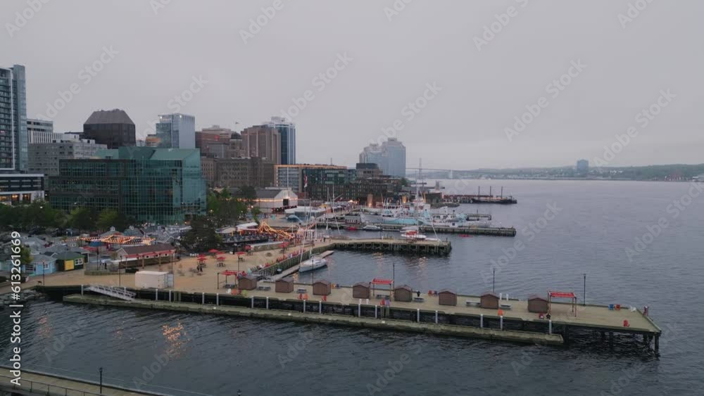 Aerial View Metropolis With Skyscrapers in the Evening Overlooking the Ocean, Halifax, Canada. Cinematic Drone Shot at downtown. Embankment with Moored Boats, Restaurants Shore Cloudy Summer Evening. Aerial View Metropolis With Skyscrapers in the Evening Overlooking the Ocean, Halifax, Canada. Cinematic Drone Shot at downtown. Embankment with Moored Boats, Restaurants Shore Cloudy Summer Evening.