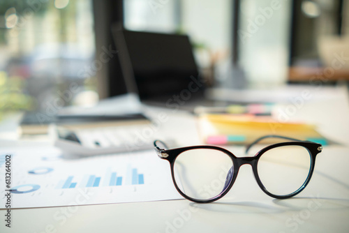 eye glasses placed on the desk are eye glasses that are prepared for people with farsightedness to work and read documents clearly. The concept of wearing eye glasses for normal vision