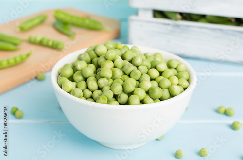 Composition with fresh green peas on wooden table