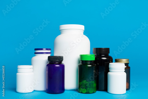 Plastic bottles for vitamins on color background