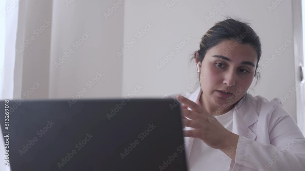 Enthusiastic Caucasian female medical doctor navigates an interactive webinar conference via laptop. Engaging in digital healthcare concept Enthusiastic Caucasian female medical doctor navigates an interactive webinar conference via laptop. Engaging in digital healthcare concept