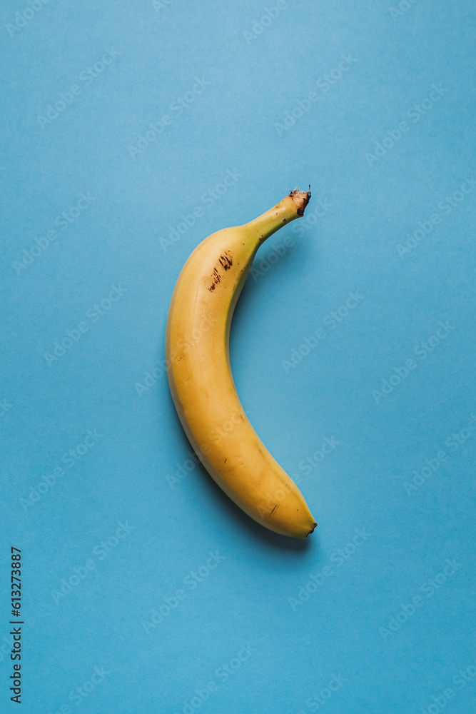 A isolated yellow banana on a blue background. Healthy lifestyle concept.