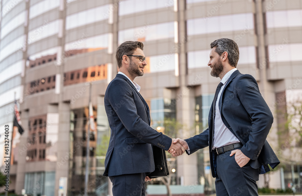 two businessmen deal with handshake outdoor, copy space. two businessmen in suit deal two businessmen deal with handshake outdoor, copy space. two businessmen in suit deal