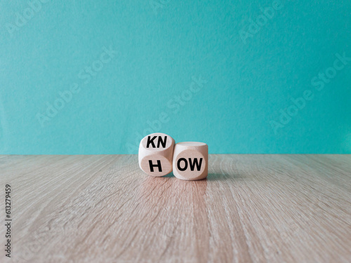 Know how and business concept. Turned cube and changed the word 'how' to 'know'. Beautiful wooden table, blue background. Copy space. photo