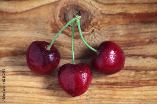 Three cherries on a wooden background
