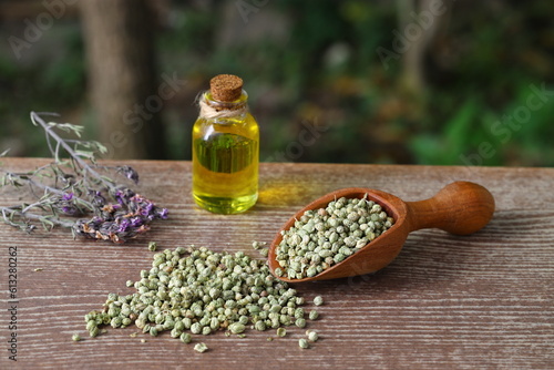 thyme essential oil and Heap of dry thyme in wooden spoon and in bowl on wooden background. Dried spice zahter thyme and oil concept photo