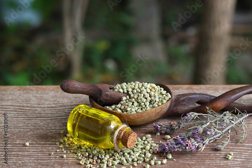 thyme essential oil and Heap of dry thyme in wooden spoon and in bowl on wooden background. Dried spice zahter thyme and oil concept photo