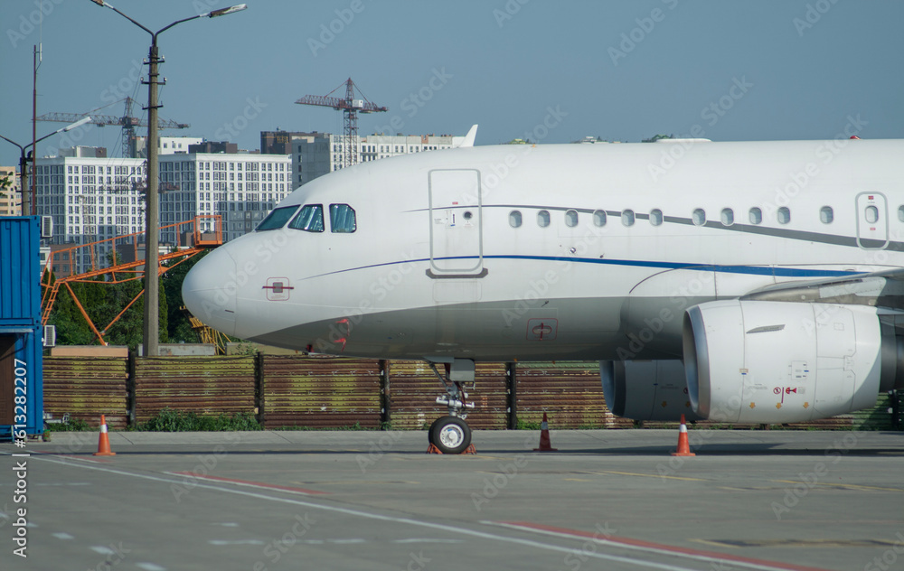 A white, passenger, twin-engine, medium-haul aircraft is parked in a parking lot at an airport. The plane is preparing to fly, aviation, sky, travel, aviation A white, passenger, twin-engine, medium-haul aircraft is parked in a parking lot at an airport. The plane is preparing to fly, aviation, sky, travel, aviation