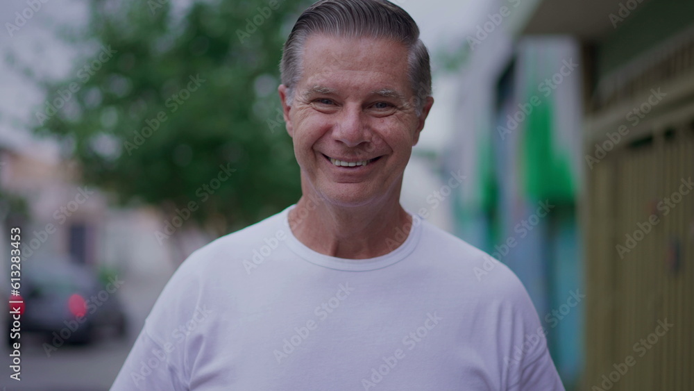 One happy older man walking toward camera in city street smiling. Close-up face of a middle-age person One happy older man walking toward camera in city street smiling. Close-up face of a middle-age person