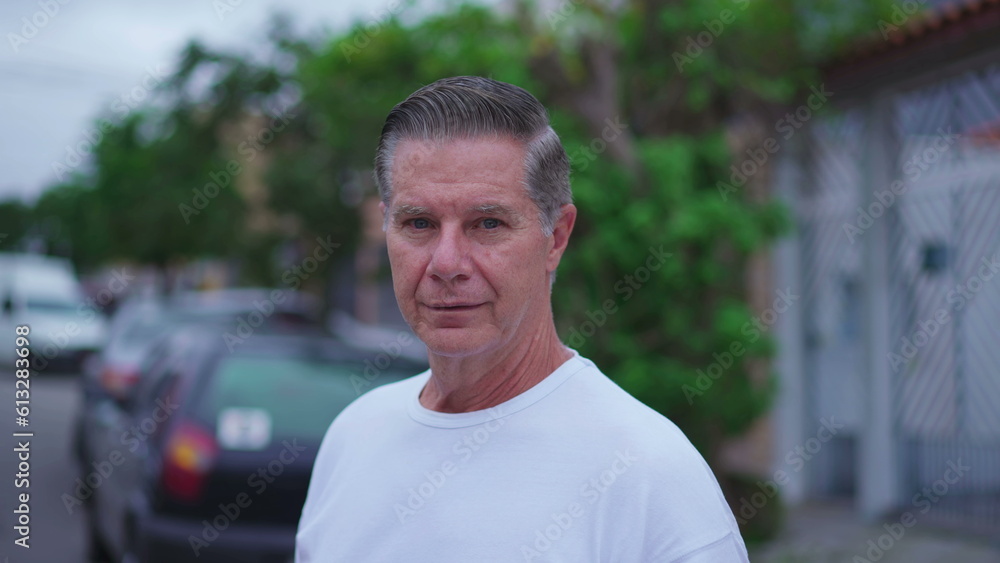 Portrait of a middle-aged man standing in street looking at camera. Close-up face of an older male caucasian person in 50s. Tracking shot Portrait of a middle-aged man standing in street looking at camera. Close-up face of an older male caucasian person in 50s. Tracking shot
