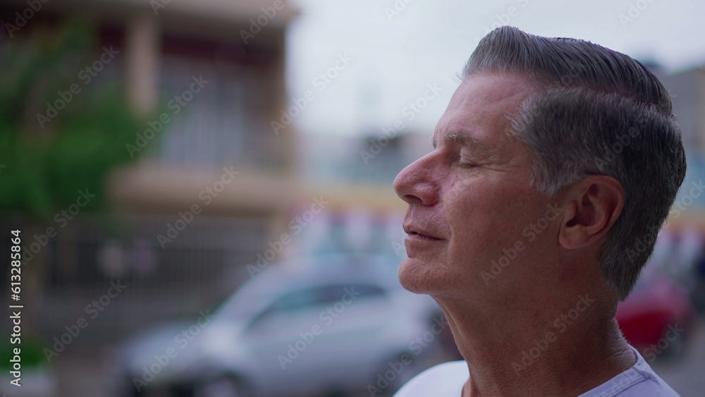 Grateful senior man opening eyes to sky with HOPE and FAITH. Contemplative meditative older person having GRATITUDE Grateful senior man opening eyes to sky with HOPE and FAITH. Contemplative meditative older person having GRATITUDE