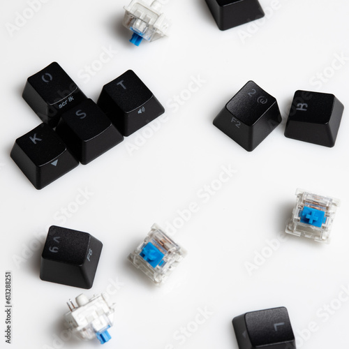 Keycaps and Keyswitch for Mechanical Keyboards Scattered on White Background