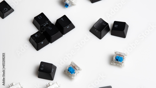 Keycaps and Keyswitch for Mechanical Keyboards Scattered on White Background